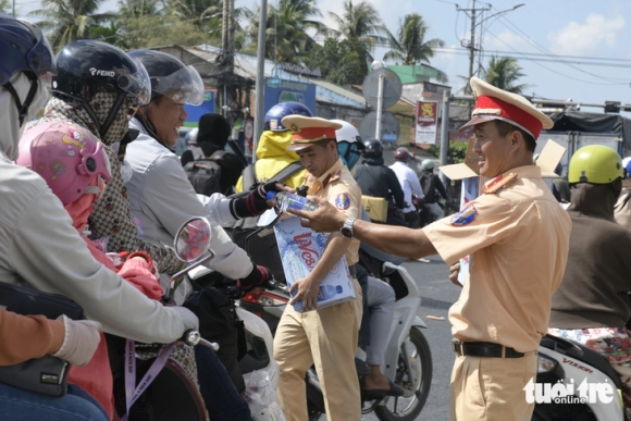 1 Canh Sat Ra Quoc Lo 1 Phat Nuoc Uong Khan Lanh Cho Nguoi Dan Ve Que Nghi Le