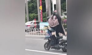 Cảnh sát Trung Quốc truy tìm cô gái đứng một chân trên xe máy điện