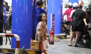 Trẻ em “vạ vật” chờ cha mẹ xếp hàng mua xăng lúc nửa đêm